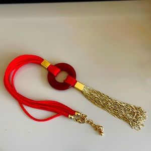 Red long necklace with circular broach